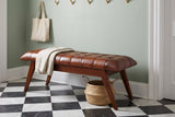 Bevagna cognac leather bench in a Charleston entry hall with a sage-green plaster wall, a black-and-white checkerboard marble floor, a folded linen throw and a seagrass basket