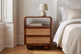 Bitti chestnut mango and cane nightstand against a white-painted brick wall in a Brooklyn brownstone bedroom with a herringbone oak floor