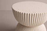 Close-up of the scalloped rim and ribs of the Bivona side table in beige MGO with a hand-applied speckled finish