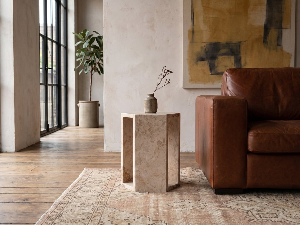 Bojano Rosa Marble Hexagon Side Table beside a leather sofa in an industrial loft