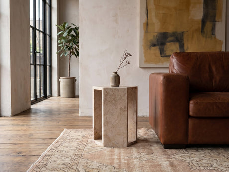 Bojano Rosa Marble Hexagon Side Table beside a leather sofa in an industrial loft