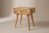 The Bonorva one-drawer nightstand in light mango with a dark round knob, rounded corners and four splayed round legs, three-quarter view on a light studio backdrop