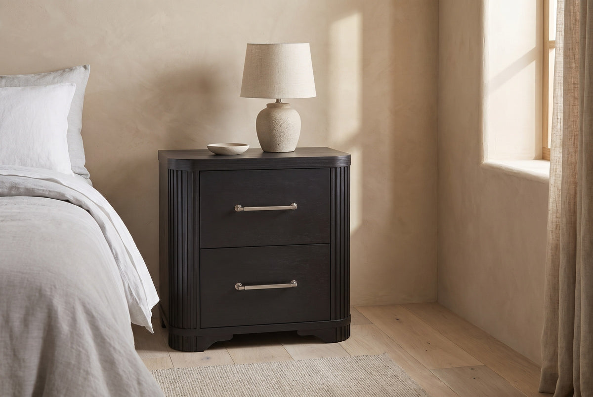 Bosa charcoal oak nightstand with a ceramic lamp against a warm sand Roman clay wall in an Austin bedroom with pale oak floorboards