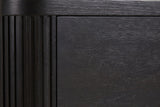 Close-up of the Bosa nightstand: charcoal-stained oak with open grain beside a rounded reeded corner