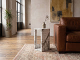 Bovino White Marble Hexagon Side Table beside a leather sofa in an industrial loft