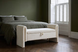 Bracciano cream teddy bench at the foot of a bed with olive linen bedding in a Brooklyn brownstone bedroom with a deep olive green wall and a dark herringbone floor (bed not included)