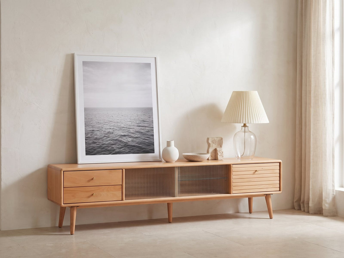 Bressanone Solid Beech Media Console styled with a leaning print, a lamp and ceramics in a bright plaster room