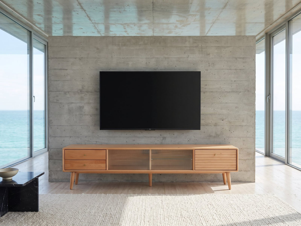 Bressanone Solid Beech Media Console under a wall-mounted screen in an oceanfront glass house