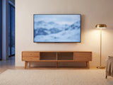 Bressanone Solid Beech Media Console under a screen showing a snowy landscape on a winter evening