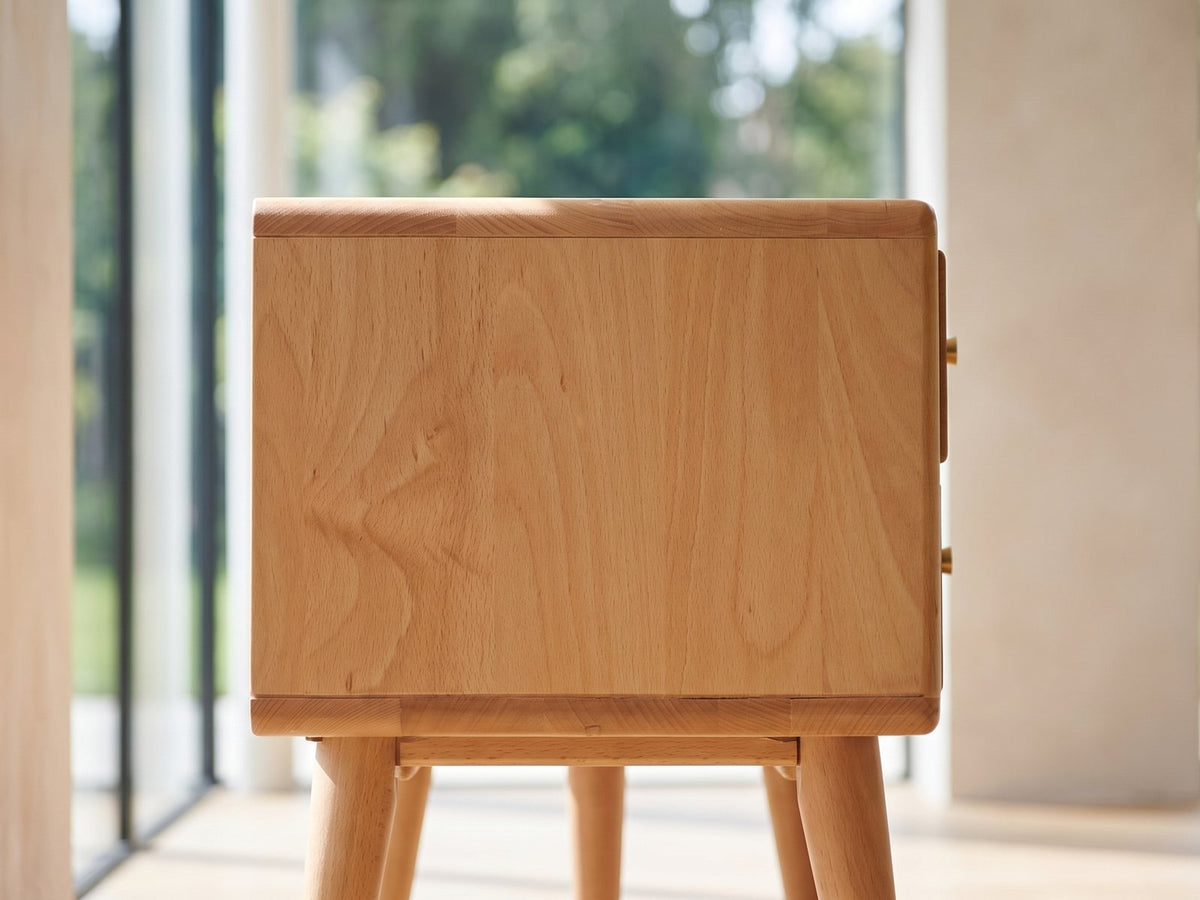 Close-up of the Bressanone Solid Beech Media Console: the end panel of the solid beech case with its rounded edge and the two round tapered legs below