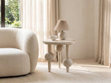 Brienza Reclaimed Pine Sphere-Leg Side Table with a lamp and a ceramic bowl beside a cream boucle armchair in a bright plaster room