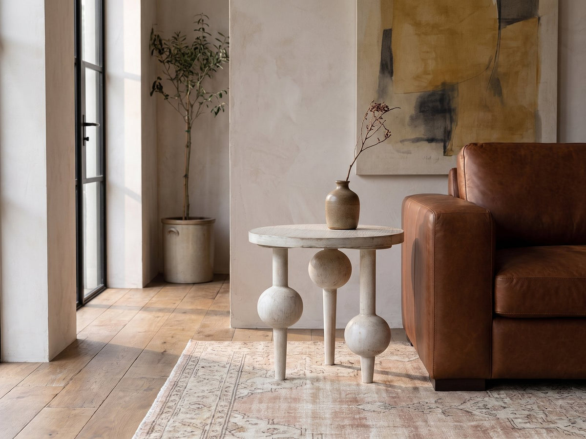 Brienza Reclaimed Pine Sphere-Leg Side Table beside a leather sofa in an industrial loft