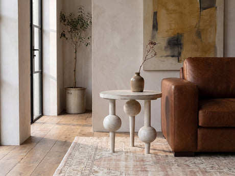Brienza Reclaimed Pine Sphere-Leg Side Table beside a leather sofa in an industrial loft