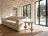 Brienza Reclaimed Pine Sphere-Leg Side Table beside a linen sofa in a poolside villa