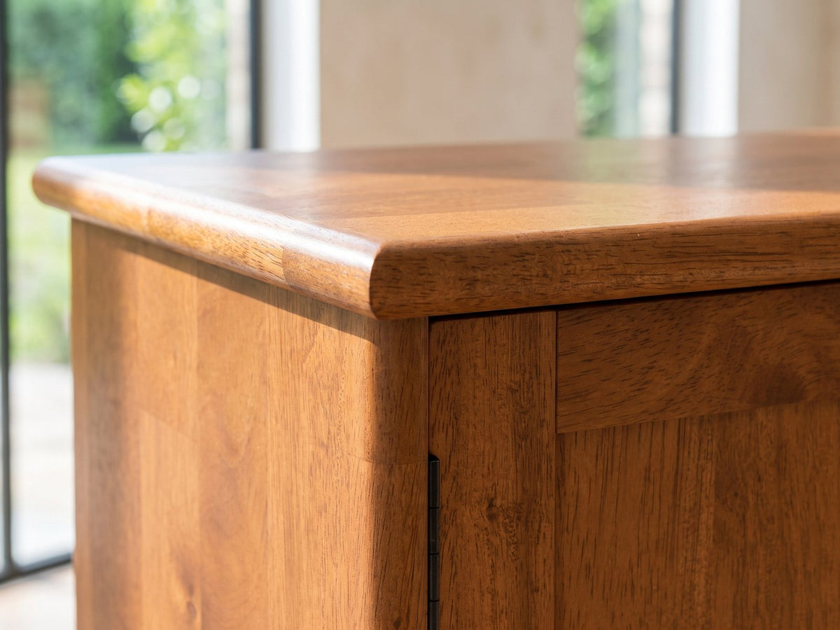 Close-up of the Brisighella Mid-Century Media Console: the top corner of the console: the solid wood top edge and the door below with its slim black pull