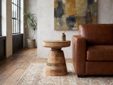 Bronte Solid Mango Pedestal Side Table beside a leather sofa in an industrial loft