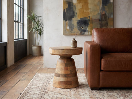 Bronte Solid Mango Pedestal Side Table beside a leather sofa in an industrial loft