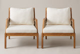 The two Buccheri club chairs seen from the front: square acacia legs, a flat acacia seat frame, ivory seat cushions and tall back cushions