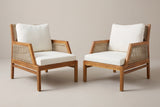 The set of two Buccheri acacia and wicker club chairs with ivory cushions, turned slightly towards each other on a light studio backdrop