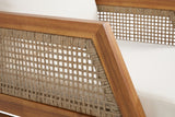 Close-up of a Buccheri arm: the acacia arm rail meeting the slanted front member, the open flat-wicker grid inside and the ivory cushion beside it