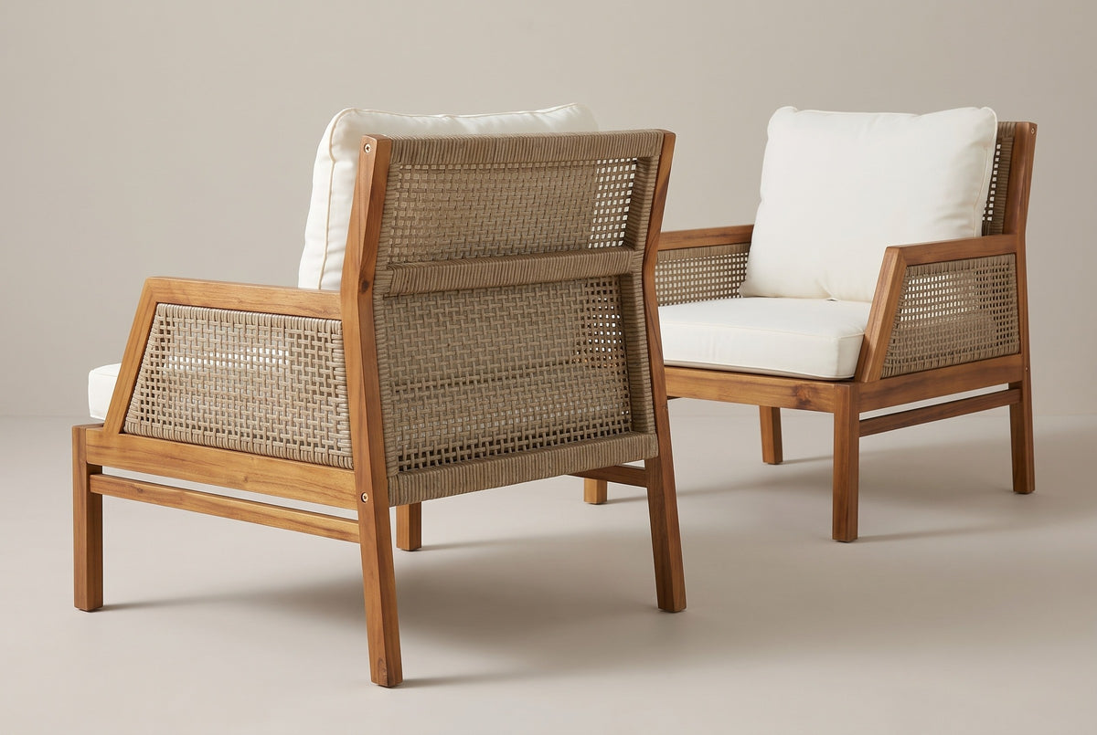 A Buccheri club chair from behind: two open-weave wicker panels between square acacia posts, a slanted arm frame and the side stretcher, the second chair beyond