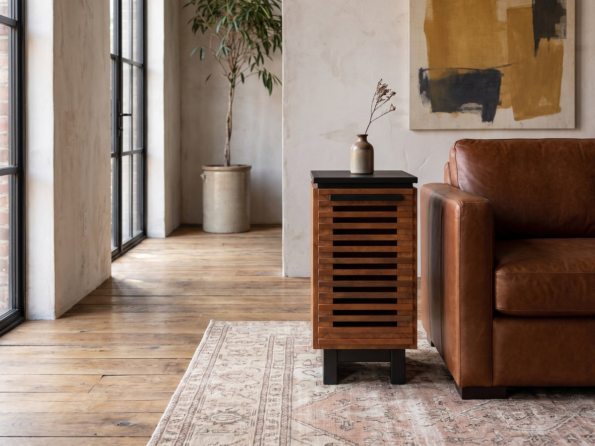 Buonvicino Bourbon and Black Slatted Side Table beside a leather sofa in an industrial loft