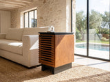 Buonvicino Bourbon and Black Slatted Side Table beside a linen sofa in a poolside villa