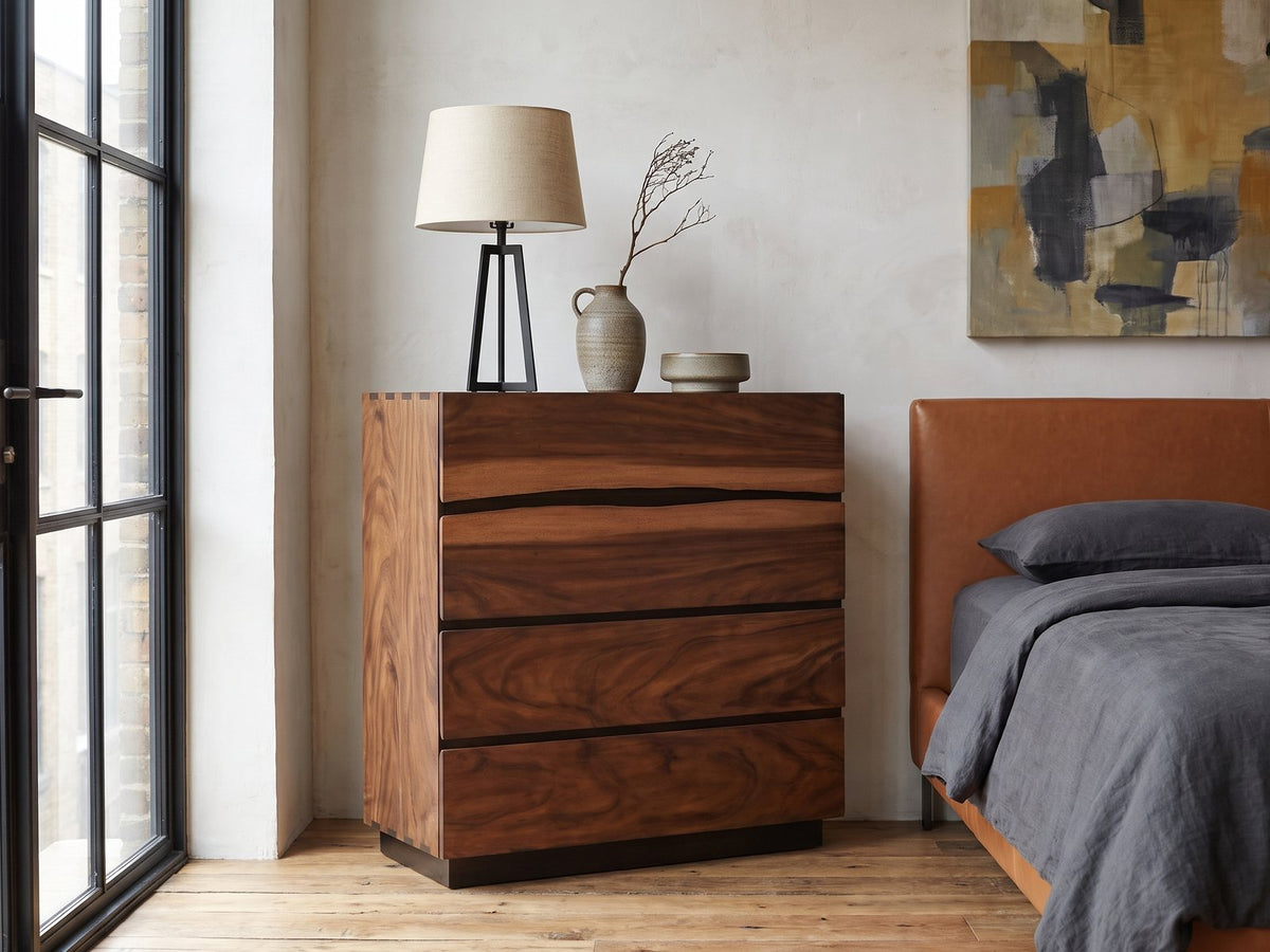 Burano 40-Inch Smokey Walnut 4-Drawer Chest against a plaster wall in an industrial loft bedroom