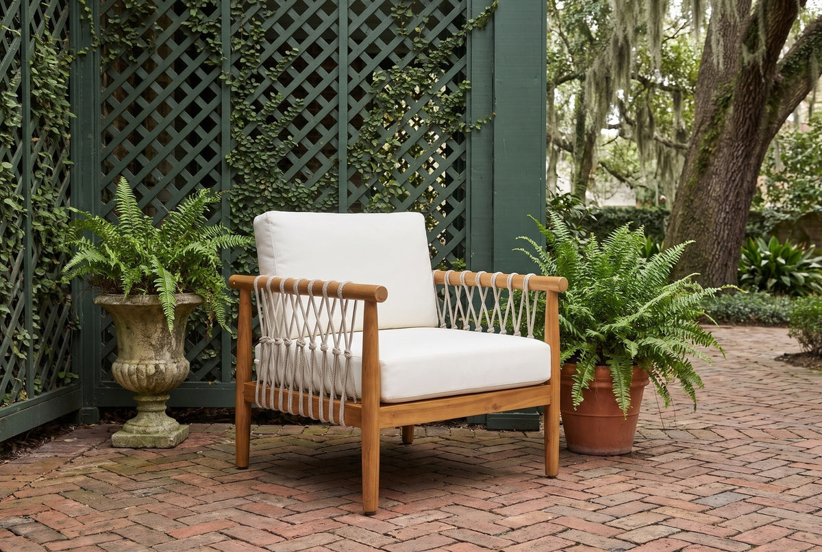 Burgio acacia and rope club armchair on herringbone brick in a Savannah courtyard garden, a dark green lattice wall with creeping fig and a live oak behind (plants and urn not included)