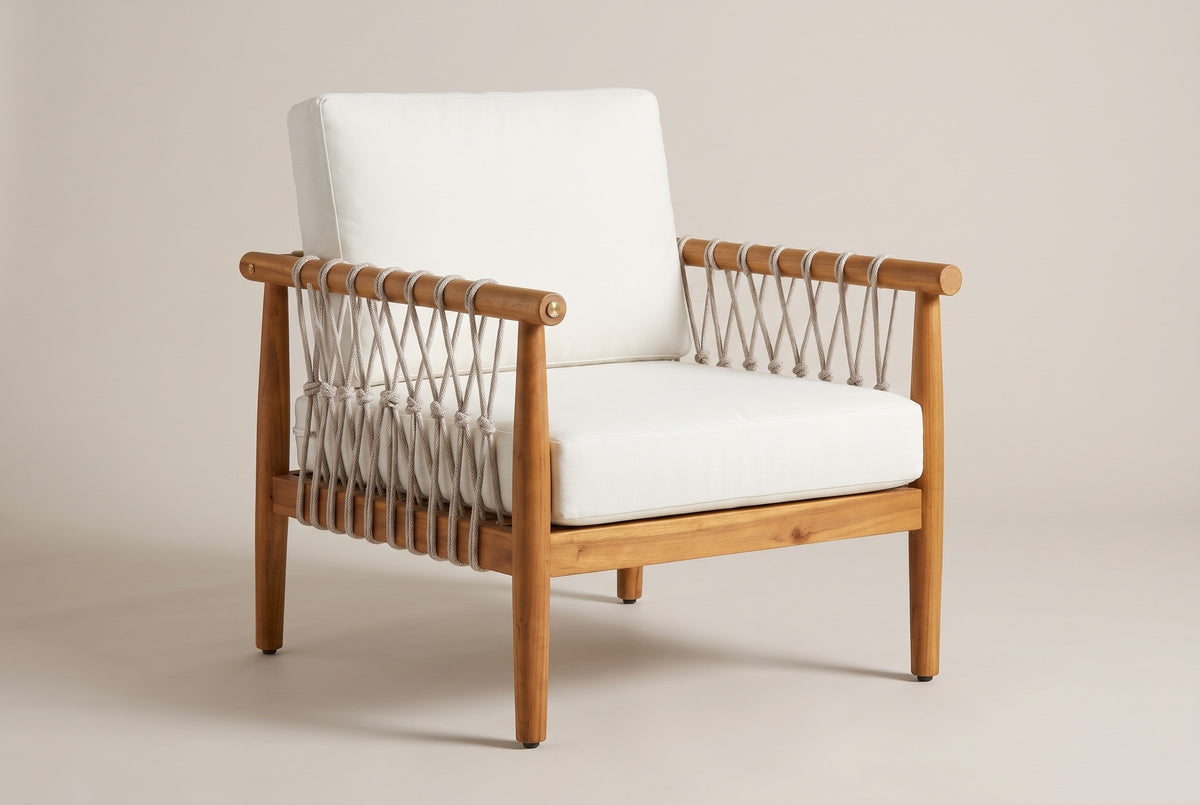The Burgio outdoor club armchair in teak-finish acacia with beige rope lacing and cream seat and back cushions, three-quarter view on a light studio backdrop