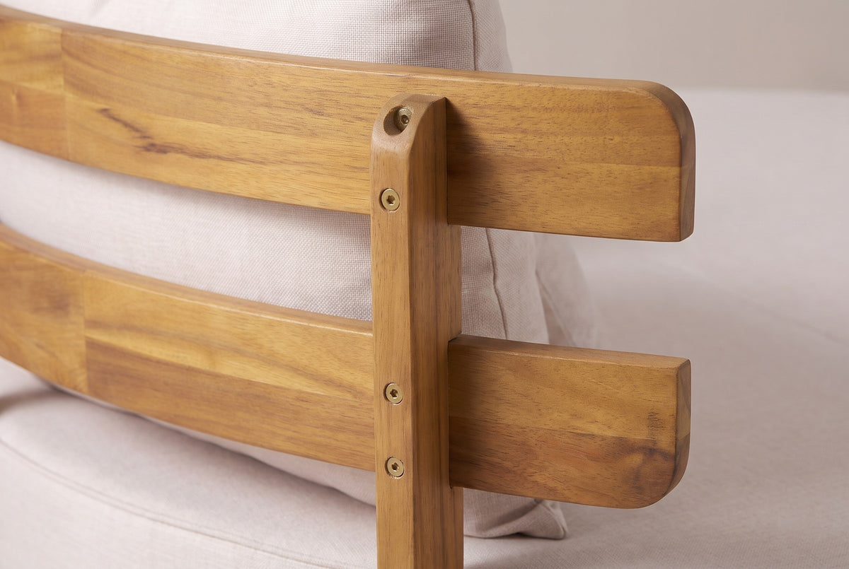 Close-up of the acacia on the Butera daybed: two curved backrest slats crossing a square post with brass-coloured screw heads