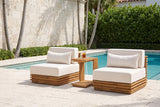 Calamosche acacia chat set by a pool in a Coral Gables courtyard, a pale coral stone wall, palms and a sea-grape hedge behind