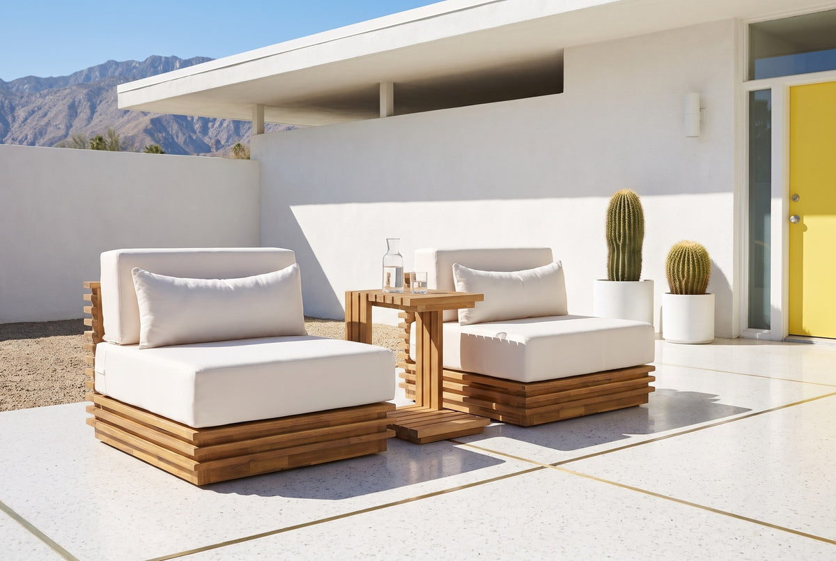 Calamosche acacia chat set on a white terrazzo patio in Palm Springs, a white stucco wall, a lemon-yellow door and potted barrel cacti behind
