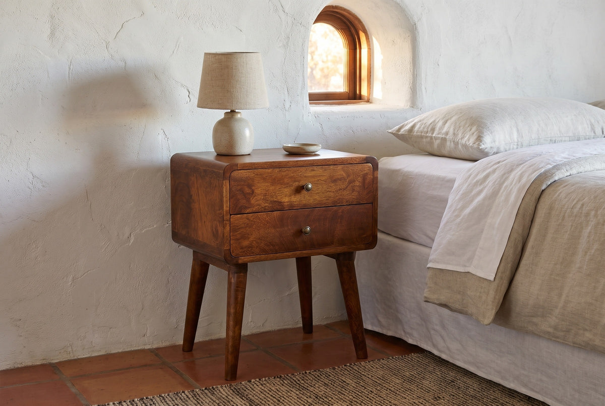 Calasetta chestnut mango nightstand against a white limewashed stucco wall in an Austin bedroom with terracotta tiles and a wool rug