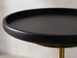 Close-up of the Calimera Black Mango and Marble Pedestal Side Table: the raised rim of the black mango tray top