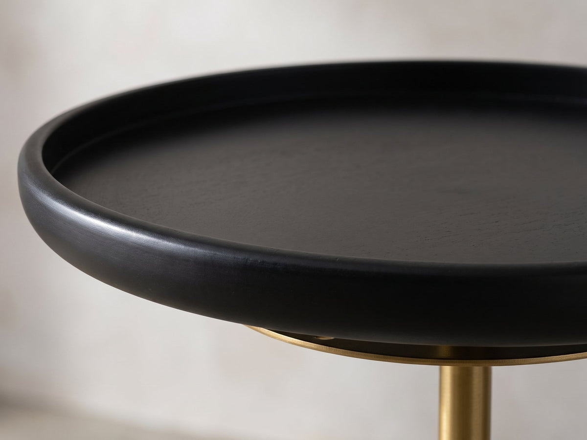 Close-up of the Calimera Black Mango and Marble Pedestal Side Table: the raised rim of the black mango tray top