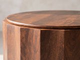 Close-up of the Camaiore Faceted Mango Drum Coffee Table: the rounded edge of the top over the faceted drum