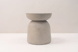 The Cammarata side table seen straight from the side: a light grey dish top, a slim neck and a bell base with nearly straight sides