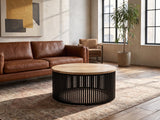 Camogli Mango and Black Metal Drum Coffee Table on a vintage rug in front of a leather sofa in an industrial loft