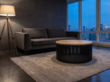 Camogli Mango and Black Metal Drum Coffee Table on a wool rug in front of a velvet sofa in a city penthouse at blue hour