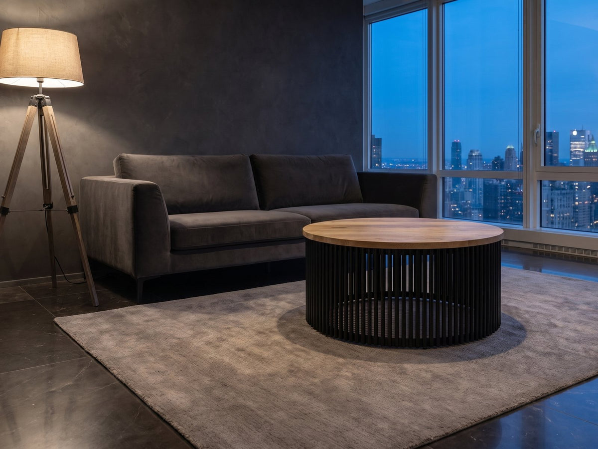 Camogli Mango and Black Metal Drum Coffee Table on a wool rug in front of a velvet sofa in a city penthouse at blue hour