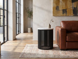 Camogli Marble and Black Metal Drum Side Table beside a leather sofa in an industrial loft