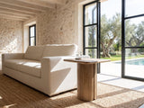 Campli Reclaimed Pine Split Pedestal Side Table beside a linen sofa in a poolside villa
