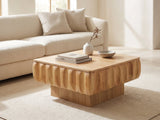 Canelli 31-Inch Square Scalloped Ash Veneer Lift-Top Coffee Table styled with books, a vase and a stone bowl in front of a cream sofa in a bright plaster room