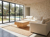 Canelli 31-Inch Square Scalloped Ash Veneer Lift-Top Coffee Table on a jute rug in front of a linen sofa in a poolside villa