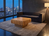 Canelli 31-Inch Square Scalloped Ash Veneer Lift-Top Coffee Table on a wool rug in front of a velvet sofa in a city penthouse at blue hour