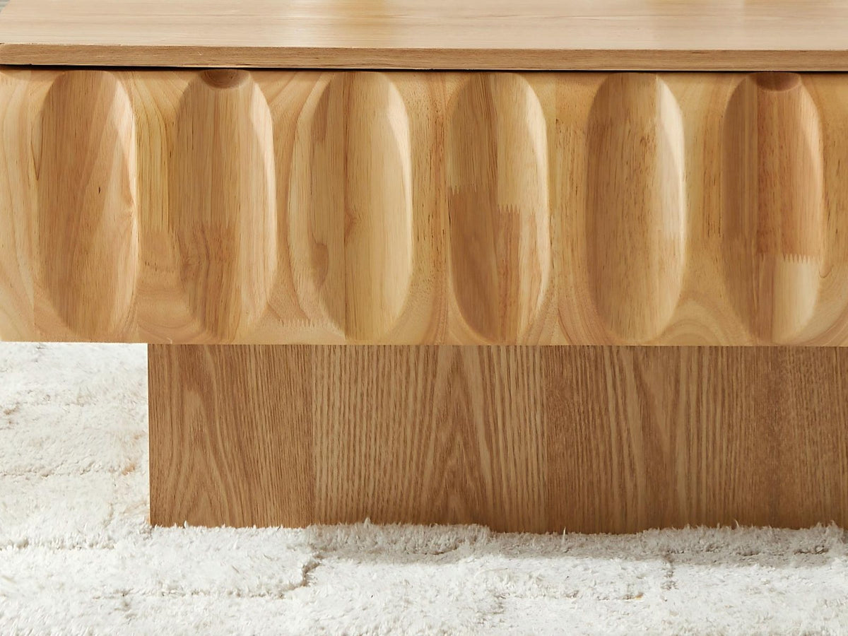 Close-up of the Canelli 31-Inch Square Scalloped Ash Veneer Lift-Top Coffee Table: the carved scoops of the solid wood band above the recessed plinth