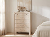 Caorle 38-Inch Weathered Mango 5-Drawer Chest against a plaster wall under an abstract canvas in a bright bedroom