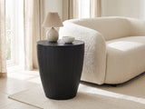 Caramanico Black Mango Tapered Drum Side Table with a lamp and a ceramic bowl beside a cream boucle sofa in a bright plaster room