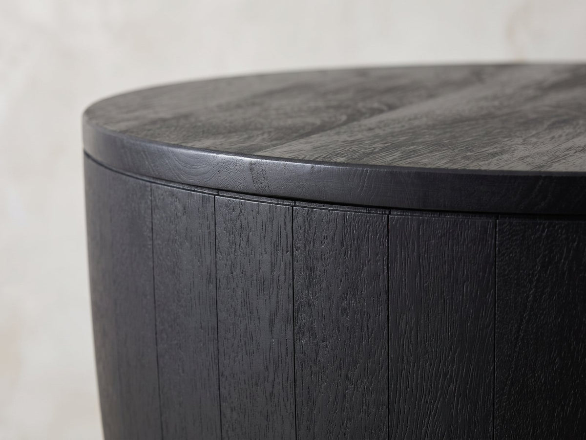 Close-up of the Caramanico Black Mango Tapered Drum Side Table: the round black top over the tapered mango staves